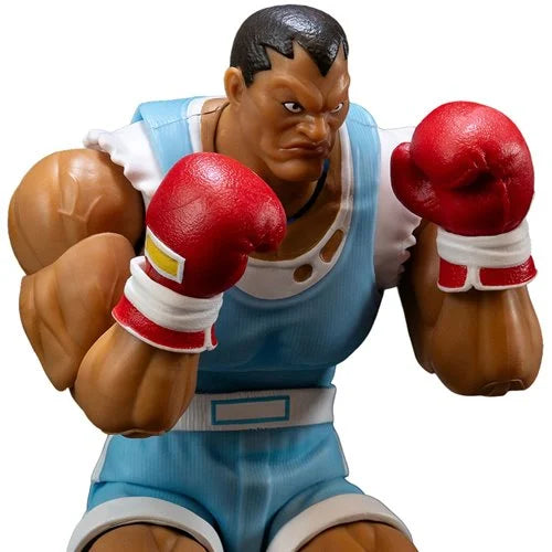 Balrog from Street Fighter in blue shorts and red gloves on a white background